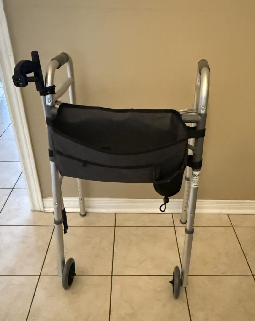 Standard walker with a front carrying pouch and attached reacher during hip replacement recovery