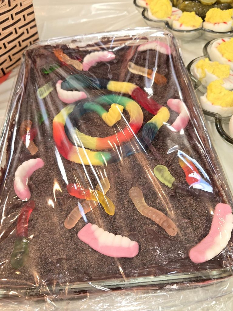 Brownies topped with gummy worms for a Halloween-themed Thanksgiving dessert.